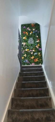 a stairway with a flower rug on the wall at Seaside Apartment in Moreton