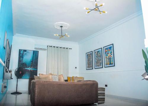 a living room with a couch and a ceiling fan at 3Tee Serviced Apartment Abeokuta in Abeokuta