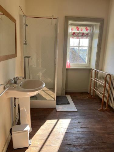 a bathroom with a sink and a glass shower at Les Glycines 23300 in La Souterraine