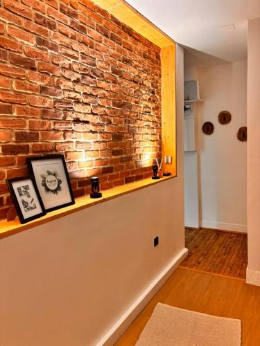 a brick wall in a room with a shelf at Refuge Éclatant Paray 4 couchages in Paray-le-Monial