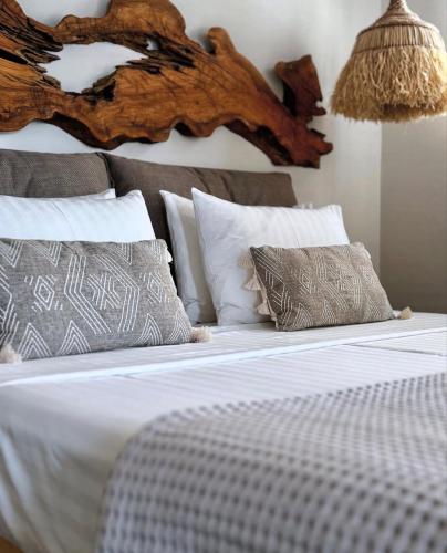 a bed with white sheets and pillows in a bedroom at Chora Suite in Alonnisos