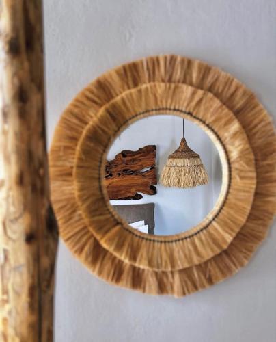 a mirror hanging on a wall with a lamp at Chora Suite in Alonnisos