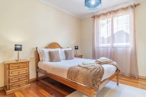 a bedroom with a bed with a dresser and a window at Vista Calheta Apartment in Calheta