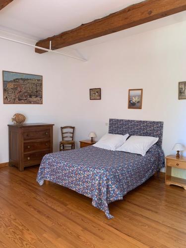 ein Schlafzimmer mit einem Bett und einem Holzboden in der Unterkunft Loberie in Montvendre