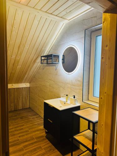 a bathroom with a sink and a mirror at Domki Pod Chełmem in Brunary Niżne