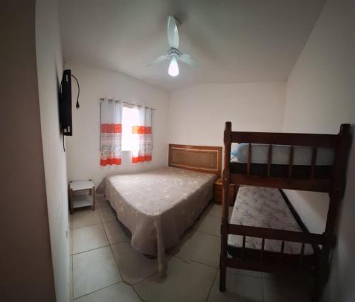 a bedroom with two bunk beds and a television at Linda Casa Mongagua COM 03 DORMS in Mongaguá