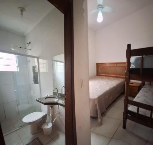a bathroom with a bed and a shower and a sink at Linda Casa Mongagua COM 03 DORMS in Mongaguá