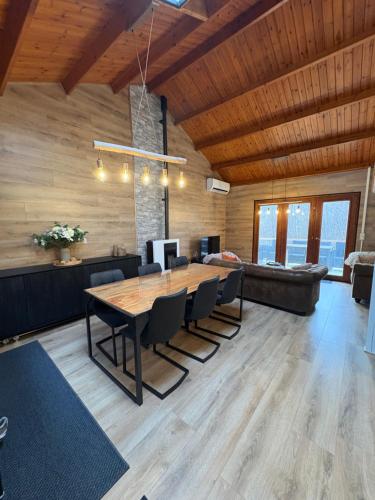 a dining room with a large wooden table and chairs at Chalet La Vallée La Boverie in Rendeux
