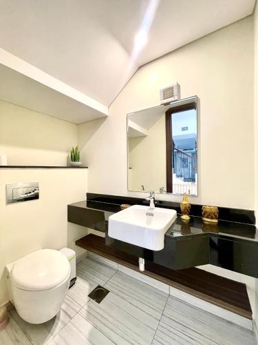 a bathroom with a white toilet and a sink at 3BR Ensuite Villa in Motor City - ShamsGetaways in Dubai