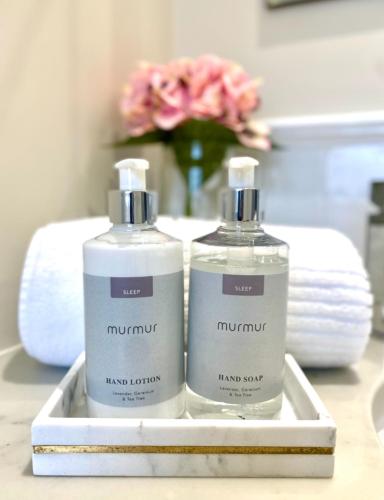 two bottles of laundry detergent sitting on a bathroom counter at Bramley House-5 Star-located on the Dublin-Belfast corridor in Loughbrickland
