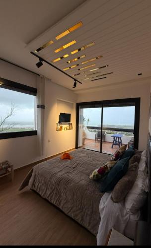 a bedroom with a large bed and a large window at Villa Casa Deraoui in Tangier