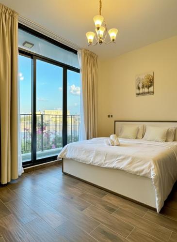 a bedroom with a large bed and large windows at 3BR Ensuite Villa in Motor City - ShamsGetaways in Dubai