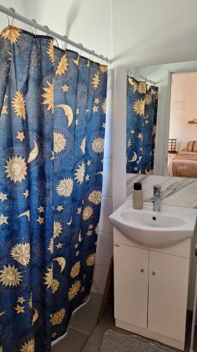 a bathroom with a sink and a shower curtain at Nyumba in Colonia Nuevo Paysandú