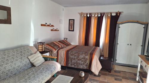 a bedroom with a bed and a couch at Nyumba in Colonia Nuevo Paysandú