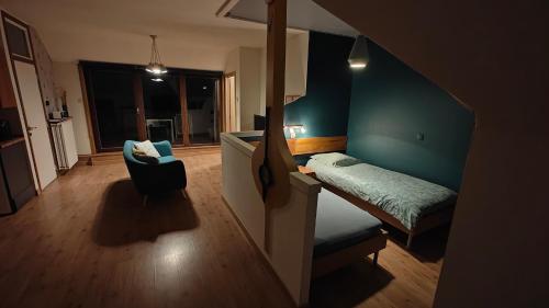a small room with a bed and a chair at Klik Klak Studio in Bornem