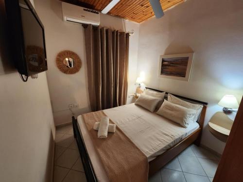 a small bedroom with a bed and a television at Blue Sea Suite Avlakia in Avlákia