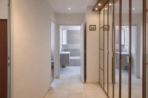 a hallway with mirrors and a bathroom with a sink at Gite Lagarrigue in Lavaur