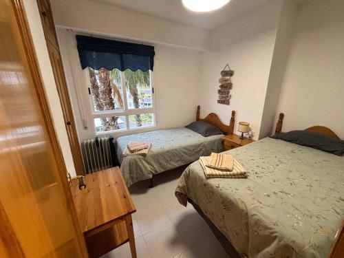 a bedroom with two beds and a window at Urbanova apartamento in El Alted