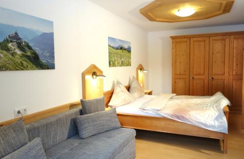 a bedroom with a bed and a couch at Ferienwohnungen Vogelrast in Berchtesgaden
