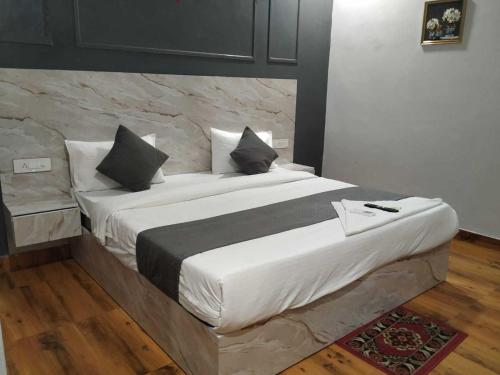 a bedroom with a large bed with white sheets and pillows at Hotel O Daffodils in Gurgaon