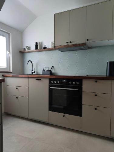 a kitchen with white cabinets and a black oven at Apartments 11 in Forchheim
