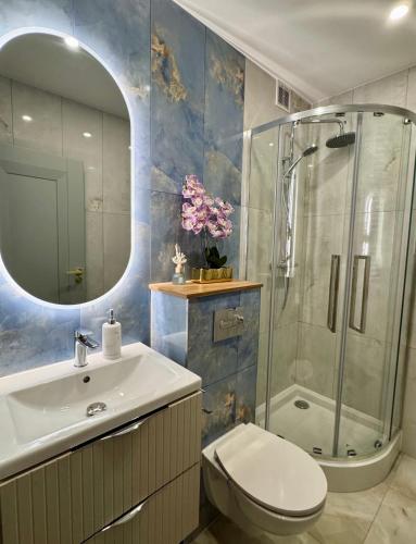 a bathroom with a toilet and a sink and a shower at Dan Apartament C, Self check-in in Opole