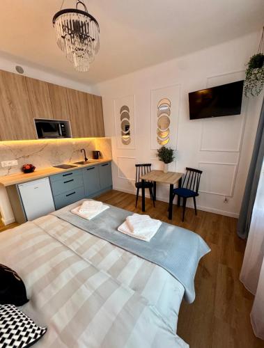 a bedroom with a large bed and a table at Dan Apartament C, Self check-in in Opole