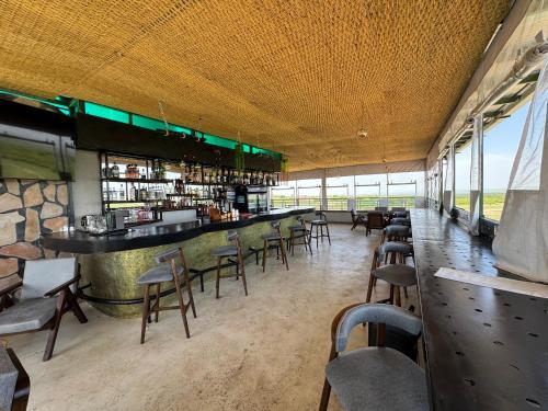 a bar in a restaurant with chairs and tables at Mara Balanite Hotel in Masai Mara