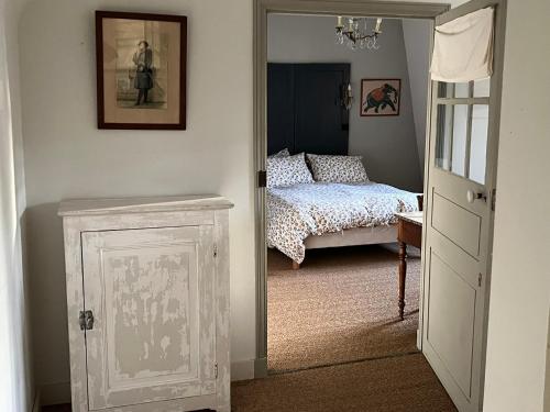 a bedroom with a bed and a door leading into a room at Les Glycines 23300 in La Souterraine