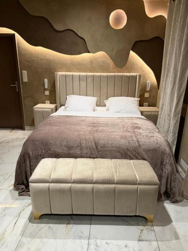 a bedroom with a large bed with a large headboard at Les Suites in Strasbourg