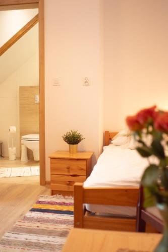 a bedroom with a bed and a vase of flowers at Zubrzyckie Pokoje in Zubrzyca Dolna