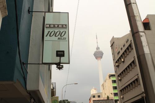a sign for a hotel with the korean tv tower in the background at Hotel 1000 Miles in Kuala Lumpur