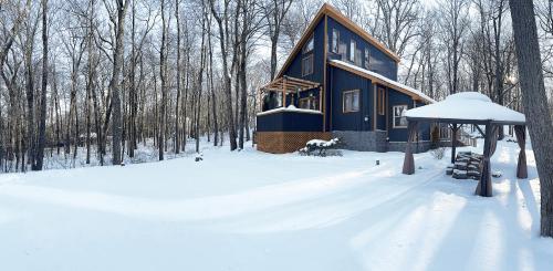 a blue house in the snow in the woods at Blackwood Cabin Pocono in Pocono Farms East