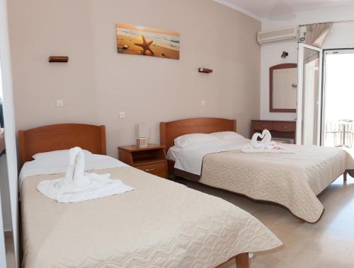 a bedroom with two beds with towels on them at Nikolaou Thomas House in Parga