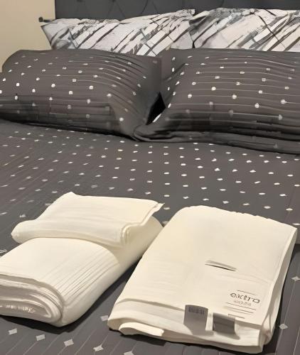 a bed with black and white sheets and pillows at Fátima Prime Loft + Breakfast in Extrema