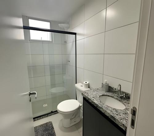a white bathroom with a toilet and a sink at Fátima Prime Loft + Breakfast in Extrema