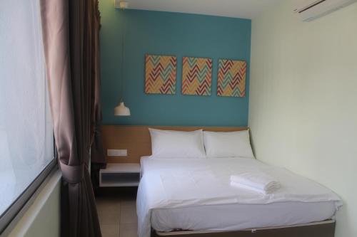 a bedroom with a bed with a blue wall at Hotel 1000 Miles in Kuala Lumpur