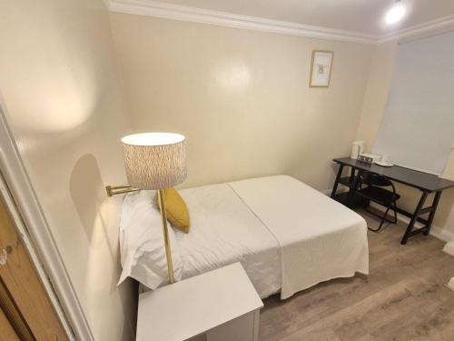 a small room with a bed and a desk at Bethel House in Kennington