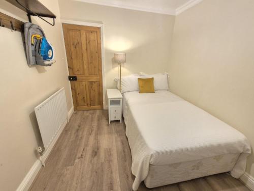 a small bedroom with a bed and a wooden floor at Bethel House in Kennington