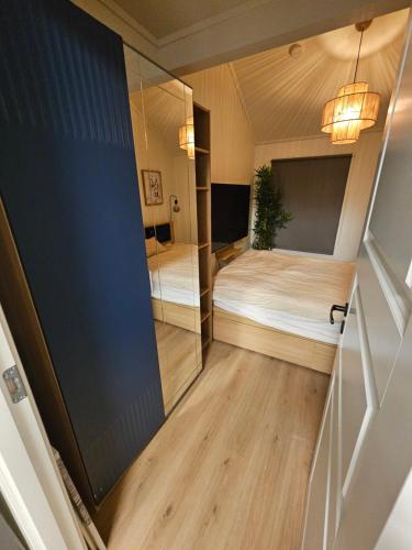 a small room with a bed and a mirror at Cozy 3-Bedroom Home in Forus in Stavanger