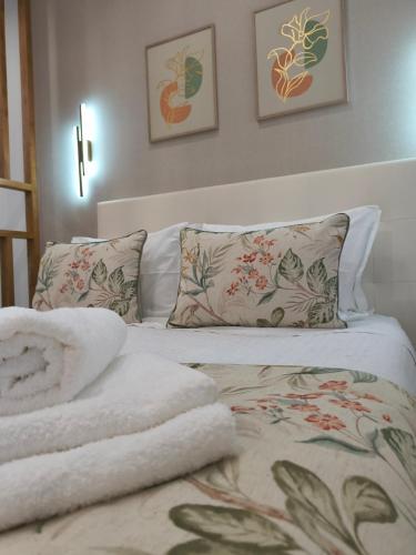 a bedroom with a bed with towels on it at Lucas House in Nazaré