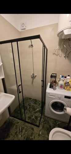 une douche dans une salle de bain avec machine à laver dans l'établissement Star Residence, à Tirane