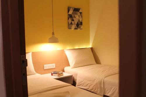a small room with two beds and a lamp at Hotel 1000 Miles in Kuala Lumpur