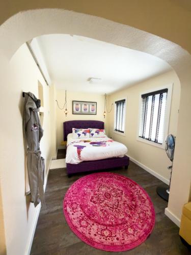 a bedroom with a bed and a pink rug at EO Bungalows, Black Hills in Custer