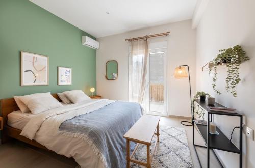 a bedroom with a large bed and a table at Kypseli Authentic Flat in Athens