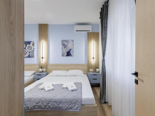 a bedroom with a bed with two pillows on it at Avenue Apartments Ilinden in Ilinden