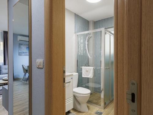 a bathroom with a toilet and a glass shower at Avenue Apartments Ilinden in Ilinden