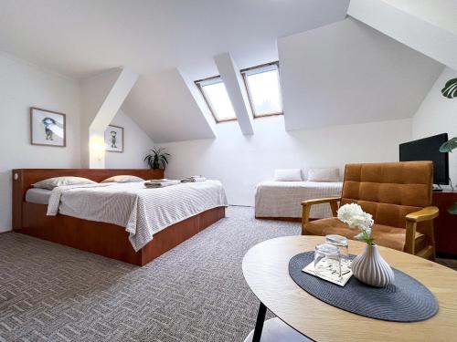 a large room with two beds and a table at Penzion Habrovická Bašta in Ústí nad Labem