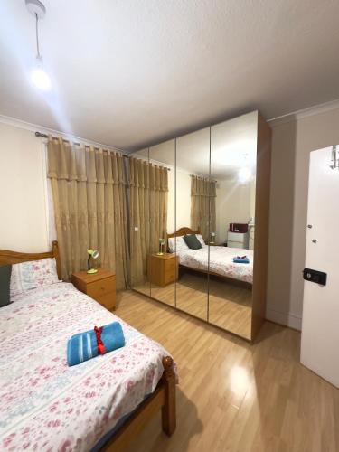 a bedroom with two beds and a large mirror at Kate House in London