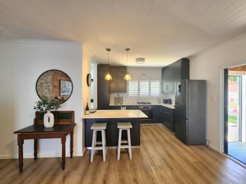 a kitchen with a counter and a table with stools at Welgelegen Self Catering in Malmesbury